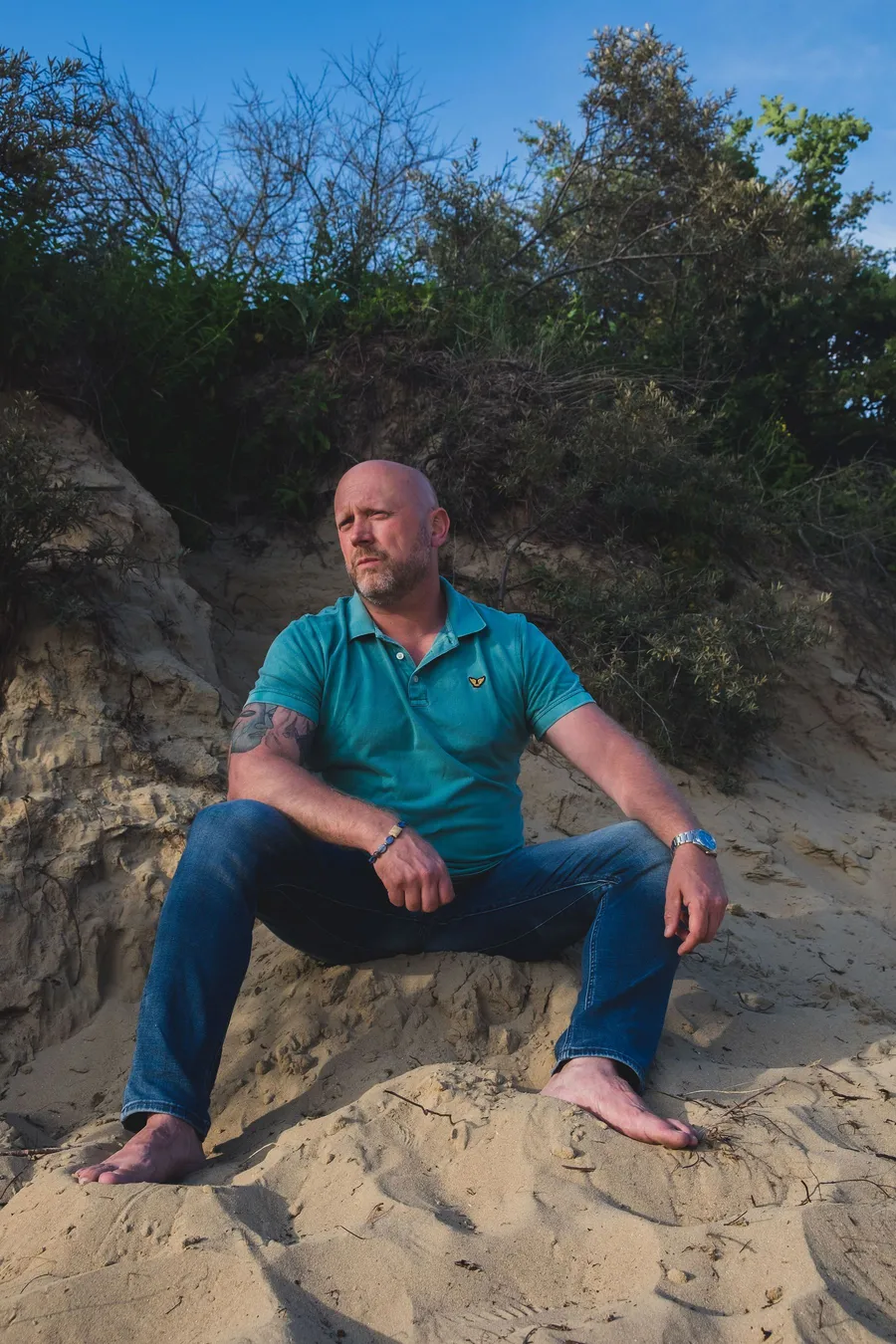 Patrick Scholten zittend in de duinen