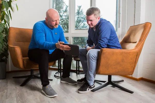 Patrick in gesprek in zijn praktijk aan huis