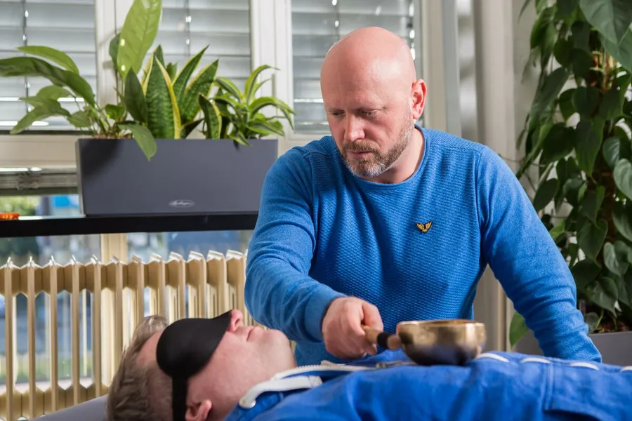 Patrick geeft een healing met een klankschaal in zijn praktijk