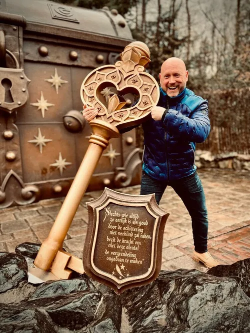 Patrick lacht naast een grote sleutel in de Efteling